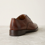 Side and heel view of the brown derby shoe