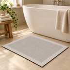 Grey bath mat in front of a freestanding bath