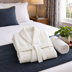 Dressing gown folded on a hotel-style bed