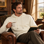 Man in the ivory premium knit hoodie reading in a country house library