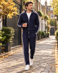 Man wearing the navy Mayfair premium knit zip tracksuit in a London mews