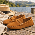 Caramel loafers on a wooden jetty with a straw hat